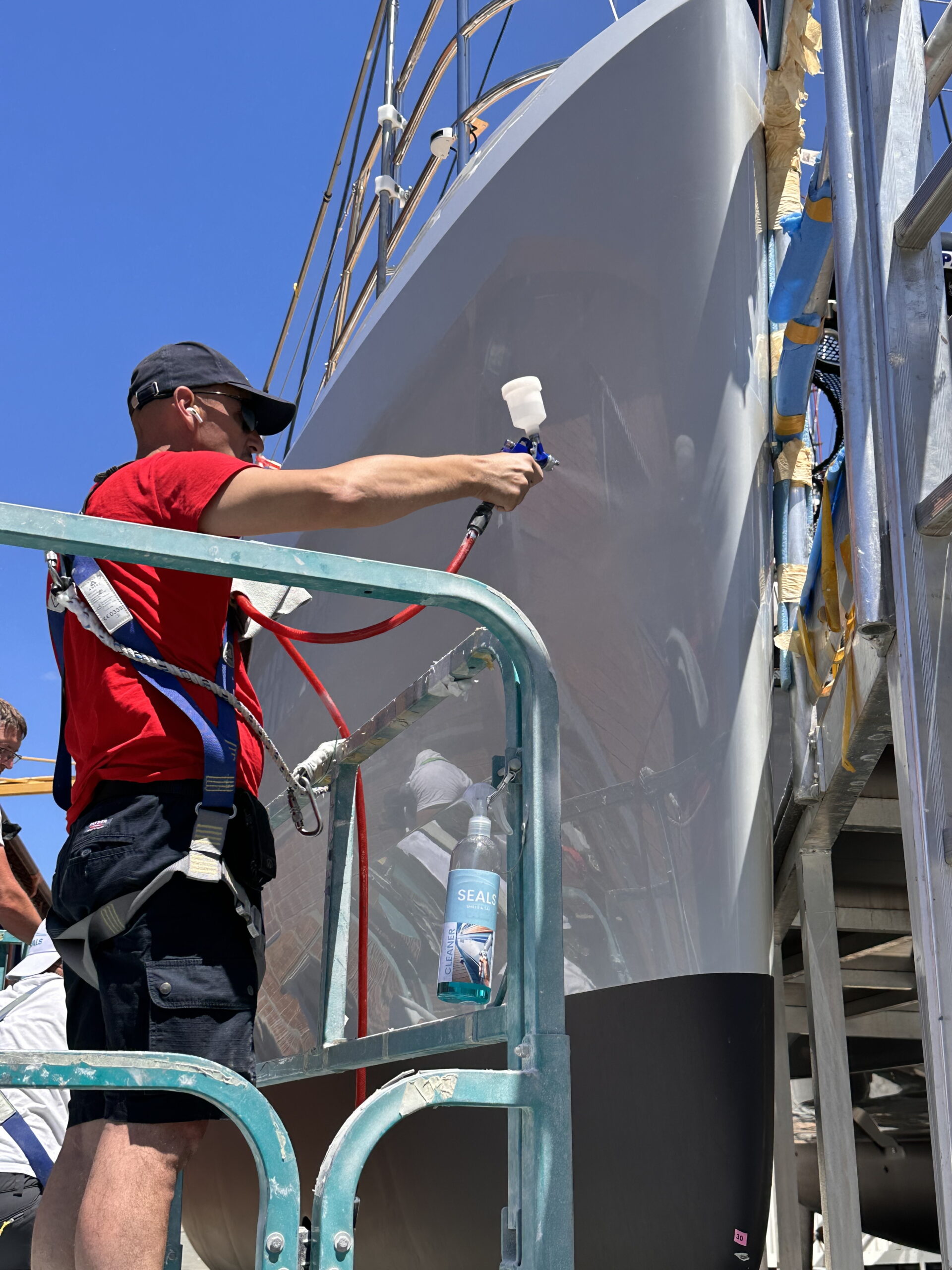 Low-pressure airbrush applying SEALS nanotech protective coating on boat surface